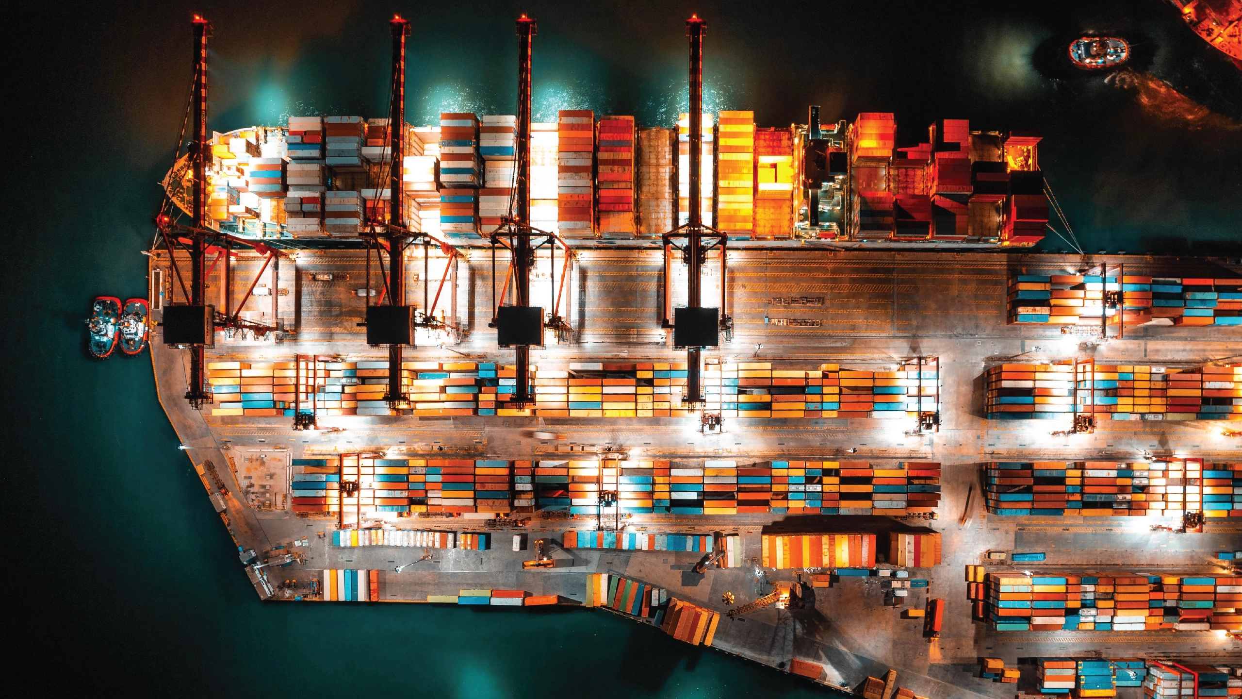 An aerial view of a container port at night.